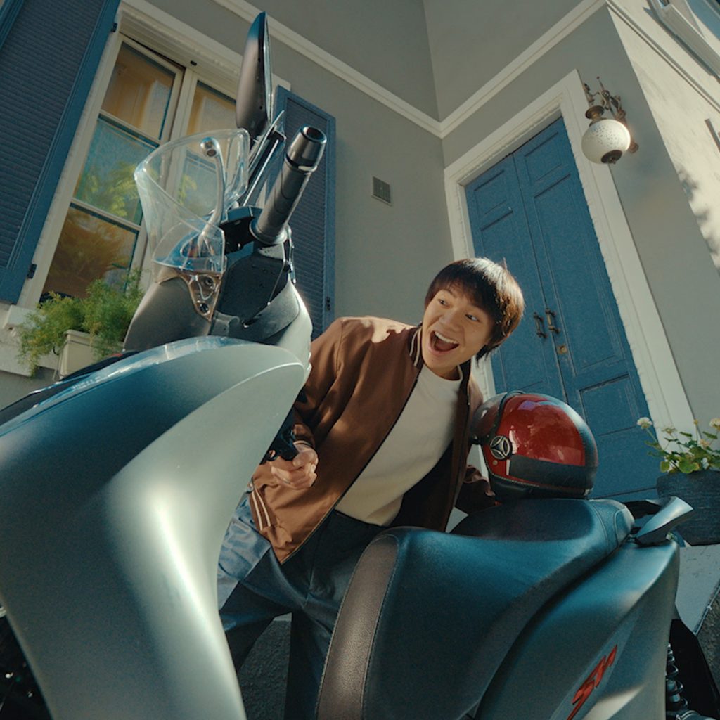 ragazzo guarda felice il suo nuovo scooter